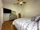Comfortable bedroom with hardwood floors and a ceiling fan, adjacent to a kitchen with a large island at 5906 Rywood Dr, Orlando, FL 32810