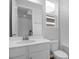 Clean bathroom features a white vanity with mirror and white tile walls with natural light at 1647 Sugarbelle Cir, Mascotte, FL 34753