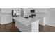 Modern kitchen with white cabinets, stainless steel appliances and a large center island at 1647 Sugarbelle Cir, Mascotte, FL 34753