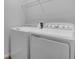Well-equipped laundry room with a side-by-side washer and dryer setup, plus convenient shelving for storage at 1647 Sugarbelle Cir, Mascotte, FL 34753
