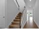 Staircase with wood railing and carpeted steps, leading to an open hallway with wood floors at 1647 Sugarbelle Cir, Mascotte, FL 34753