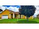 Charming yellow single-story home featuring a well-manicured lawn and a two-car garage at 9549 Sw 53Rd Cir, Ocala, FL 34476
