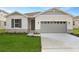 Newly constructed home with gray siding, stone accents, and a two-car garage at 4212 Sawtooth Ct, Tavares, FL 32778