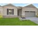 Newly constructed home with gray siding, stone accents, and a two-car garage at 4212 Sawtooth Ct, Tavares, FL 32778