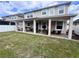Spacious backyard featuring a covered patio, lush green grass, and a white picket fence at 8118 Platts Ave, Orlando, FL 32832