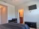 Bedroom with attached bathroom, mounted tv, and dark colored furniture at 8118 Platts Ave, Orlando, FL 32832