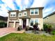 Two-story home with a two-car garage, red brick drive, and manicured landscaping at 8118 Platts Ave, Orlando, FL 32832