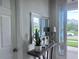 Inviting foyer with a console table, mirror, and views of the front yard at 8118 Platts Ave, Orlando, FL 32832
