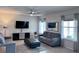 Cozy living room with plush gray sofas, a large TV, and a modern ceiling fan at 8118 Platts Ave, Orlando, FL 32832