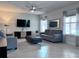 Comfortable living room featuring soft gray couches, a large TV, and a stylish ceiling fan at 8118 Platts Ave, Orlando, FL 32832