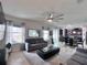 Open-concept living room boasts modern ceiling fan, comfortable seating, and seamless flow to dining area at 8118 Platts Ave, Orlando, FL 32832