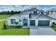 Two-story home with gray roof and white exterior, two-car garage, and landscaped lawn at 107 Hampton Loop, Davenport, FL 33837