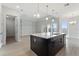 Open kitchen with dark cabinetry, large island, and access to living area at 107 Hampton Loop, Davenport, FL 33837