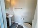 Neutral half bathroom featuring a pedestal sink, chrome hardware, and essential amenities at 1612 Herrons Green Path, Kissimmee, FL 34747