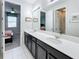 Elegant bathroom featuring double sinks, dark cabinets, and a decorative mirror at 1612 Herrons Green Path, Kissimmee, FL 34747