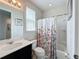 Bright bathroom features a sink, toilet, shower and tub combination, and a floral shower curtain at 1612 Herrons Green Path, Kissimmee, FL 34747