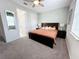 Cozy carpeted bedroom featuring a queen bed, ceiling fan, and ensuite bathroom at 1612 Herrons Green Path, Kissimmee, FL 34747