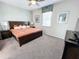 Cozy bedroom showcasing a dark wood bed, and soft lighting for a restful and inviting space at 1612 Herrons Green Path, Kissimmee, FL 34747