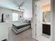 Comfortable bedroom featuring an open ensuite bathroom with double sinks and a large window for natural light at 1612 Herrons Green Path, Kissimmee, FL 34747