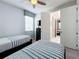 Comfortable bedroom with twin beds, striped bedding, and a ceiling fan at 1612 Herrons Green Path, Kissimmee, FL 34747