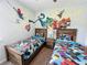 Fun ' bedroom with twin beds, wood furniture, and colorful superhero wall designs at 1612 Herrons Green Path, Kissimmee, FL 34747