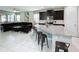 An open layout showcasing a kitchen island with countertop seating next to the living room with a dark leather sofa at 1612 Herrons Green Path, Kissimmee, FL 34747