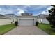 Attached garage with gray door and brick pavers driveway at 17112 Salty Dog Rd, Winter Garden, FL 34787