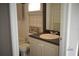 Well-lit bathroom with vanity, patterned wallpaper, and dark framed mirror at 14421 Hatchee Ct, Orlando, FL 32837