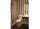 Modern bathroom with striped accent wall, floating vanity, and vessel sink at 14421 Hatchee Ct, Orlando, FL 32837