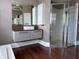 Modern bathroom featuring a sleek floating vanity, walk-in shower with glass door and wood floors at 14421 Hatchee Ct, Orlando, FL 32837