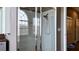 Bathroom featuring a glass-enclosed shower, tiled walls, and a window overlooking a bathtub at 14421 Hatchee Ct, Orlando, FL 32837