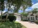 Well-manicured lawn and greenery enhance the home's curb appeal, with a view of the paved drive and garage at 14421 Hatchee Ct, Orlando, FL 32837