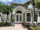 Close-up of front entrance featuring double glass doors, large windows, and manicured landscaping at 14421 Hatchee Ct, Orlando, FL 32837