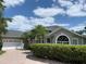 Attractive exterior view showcasing the home's architectural details, two-car garage, and paved driveway at 14421 Hatchee Ct, Orlando, FL 32837