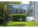 Backyard with a screened-in pool enclosure and mature landscaping at 14421 Hatchee Ct, Orlando, FL 32837