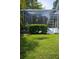 Backyard with a screened-in pool enclosure and mature landscaping at 14421 Hatchee Ct, Orlando, FL 32837