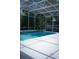 Inviting screened-in pool with cool blue water, surrounded by tropical plants and a white deck at 14421 Hatchee Ct, Orlando, FL 32837