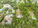 An aerial view of a property with a pool surrounded by lush greenery and neighboring homes at 1775 Sundance Dr, St Cloud, FL 34771