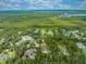 Expansive aerial shot showcases the property's lush surroundings, highlighting a serene, wooded landscape with a lake nearby at 1775 Sundance Dr, St Cloud, FL 34771