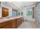 Bright bathroom featuring a double vanity, tile floors, and a large window at 1775 Sundance Dr, St Cloud, FL 34771