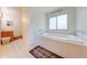 A luxurious soaking tub in a clean, bright bathroom with white tile and floral accents at 1775 Sundance Dr, St Cloud, FL 34771