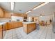 Bright kitchen boasts wood cabinets, an island with a cooktop, and a view into the adjacent dining area at 1775 Sundance Dr, St Cloud, FL 34771