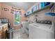 Well-equipped laundry room with modern appliances and storage shelving at 1775 Sundance Dr, St Cloud, FL 34771