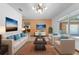Bright living room featuring neutral furniture, complementary colored pillows, and large windows at 1775 Sundance Dr, St Cloud, FL 34771