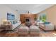 Cozy living room featuring a brick fireplace, neutral furniture, and natural light at 1775 Sundance Dr, St Cloud, FL 34771