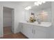 Bathroom boasts double sinks, white cabinets, and tile floors at 500 Summit River Dr, Apopka, FL 32712