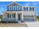 Inviting two-story home showcases a covered front porch, two-car garage, and well-maintained landscaping at 500 Summit River Dr, Apopka, FL 32712
