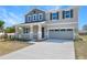 Charming two-story home featuring a two-car garage, a welcoming front porch, and eye-catching architectural details at 500 Summit River Dr, Apopka, FL 32712