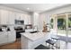 Bright, modern kitchen with white cabinets, stainless steel appliances, a large island, and sliding door access at 500 Summit River Dr, Apopka, FL 32712