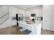 Modern kitchen with white cabinets, stainless steel appliances, a large island, and an adjacent staircase at 500 Summit River Dr, Apopka, FL 32712